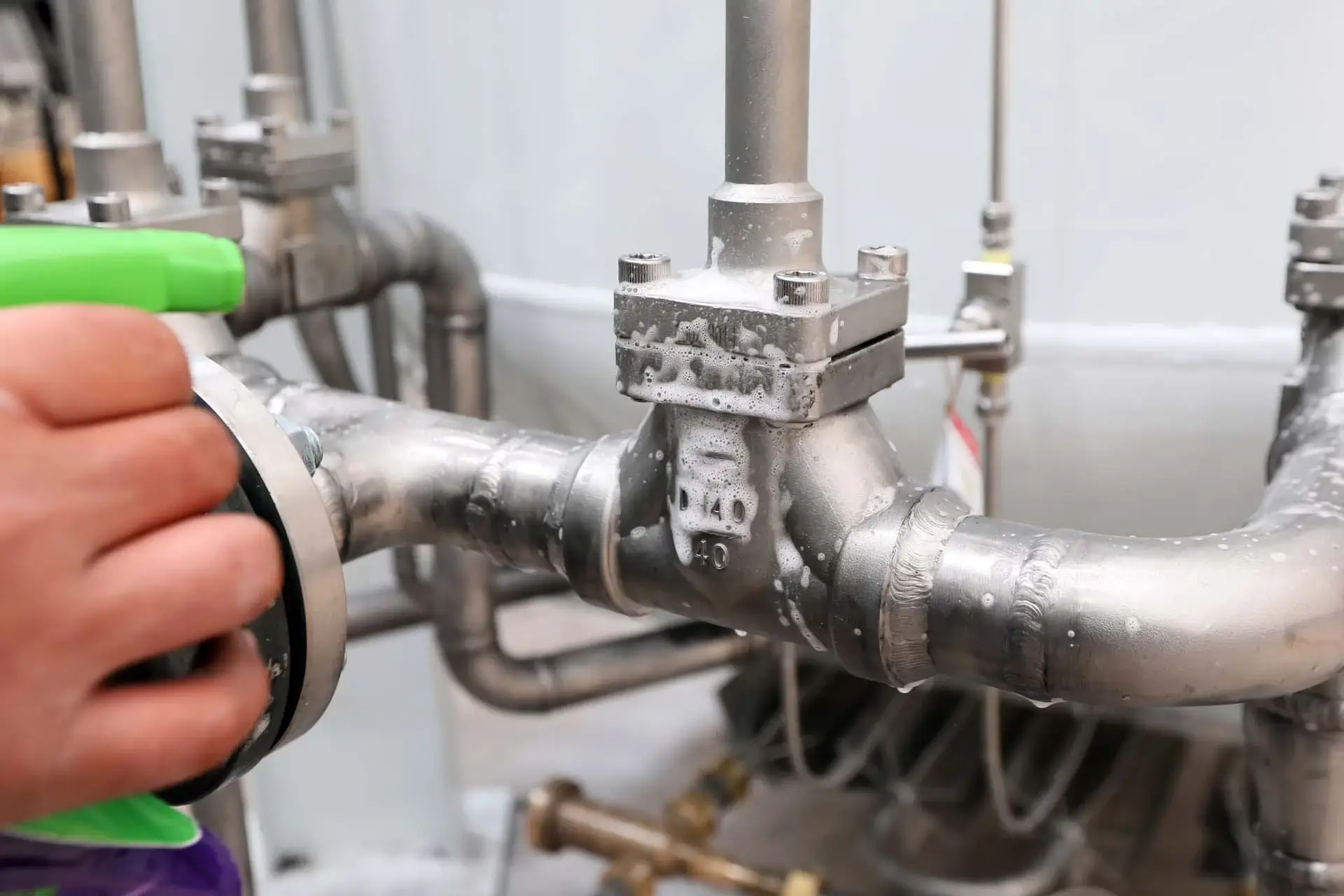 Experienced plumber inspecting pipe connections and valves with diagnostic equipment