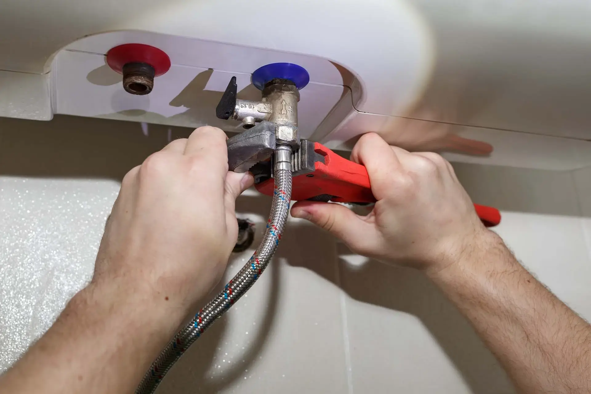 Plumber repairing under-sink pipe leak in Miramar kitchen during scheduled service call